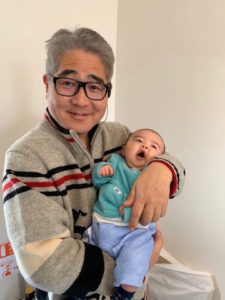 退職したスタッフの赤ちゃんを抱く院長　柴垣歯科医院