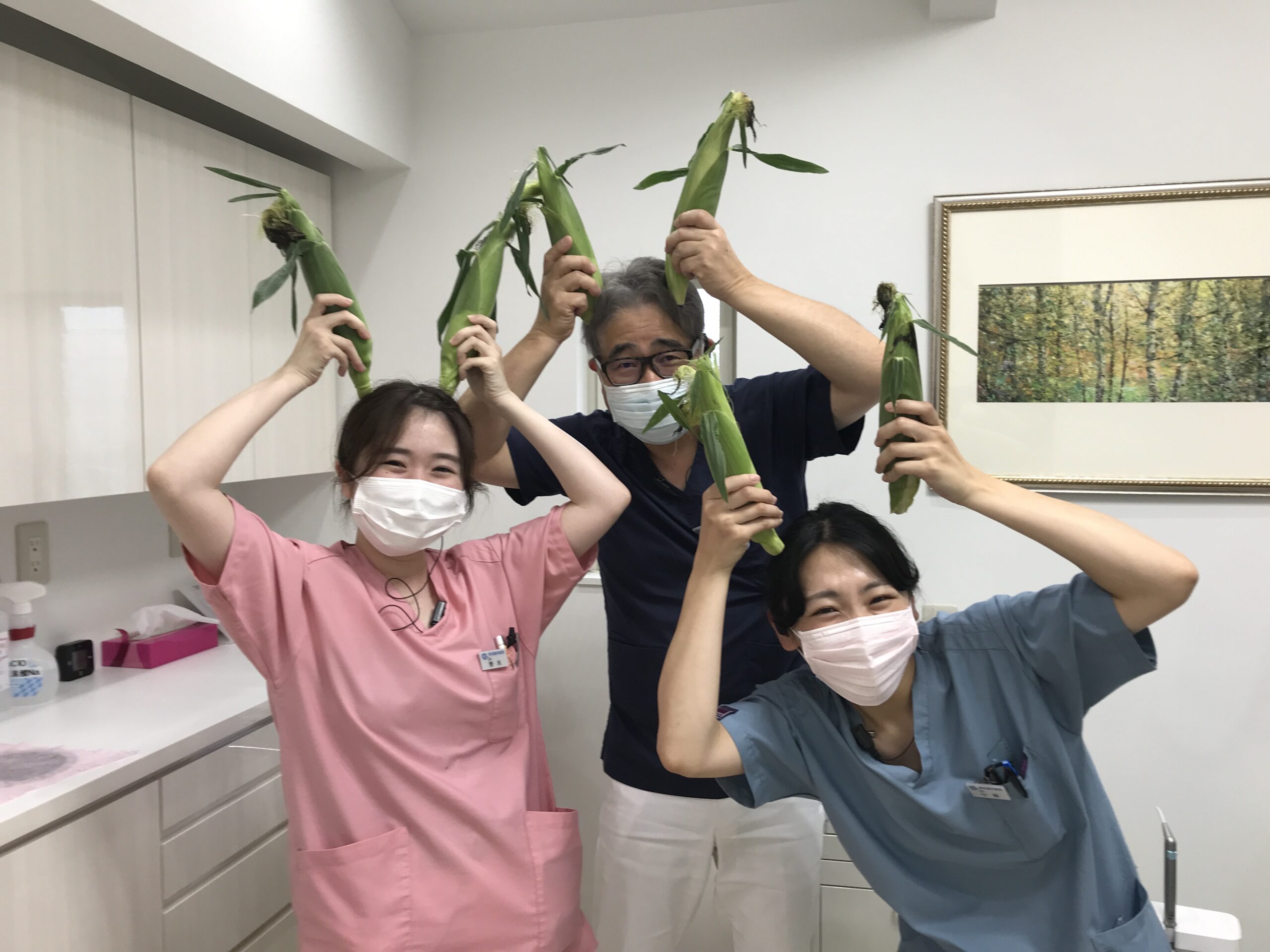 綾瀬市・海老名市の境にある柴垣歯科医院　患者様から頂いたトウモロコシと院長・スタッフ